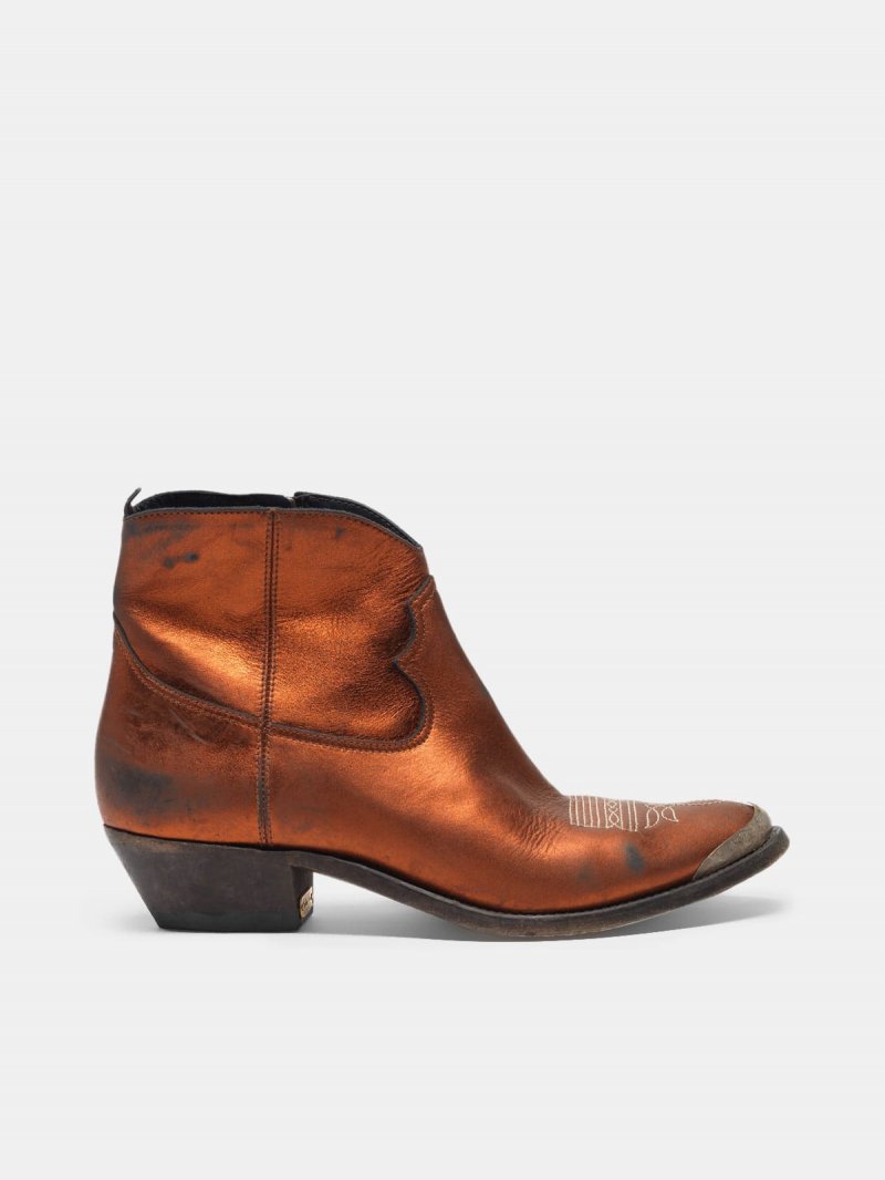 Young ankle boots in laminated leather with cowboy-style decoration